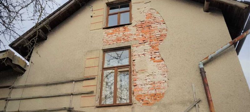 Opadaná omítka na fasádě domu